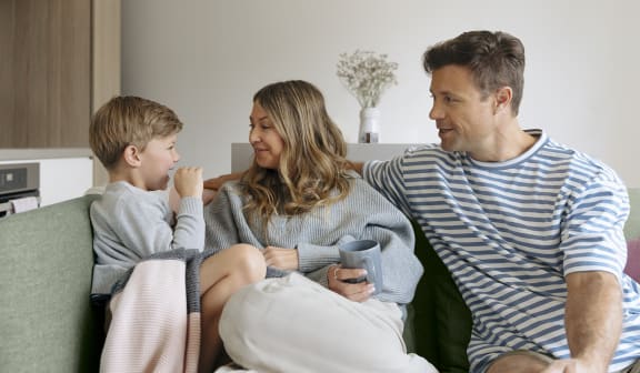 a man and woman sitting on a couch with a boy