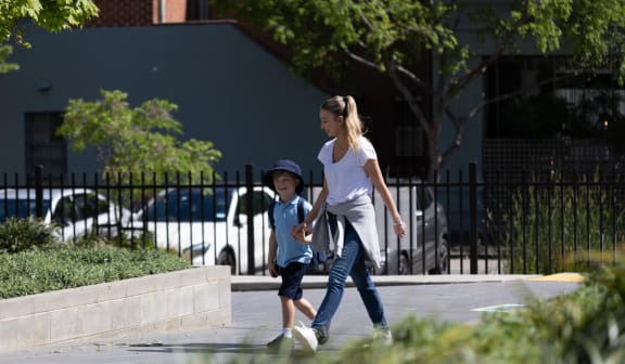 a girl and a boy walking on a sidewalk