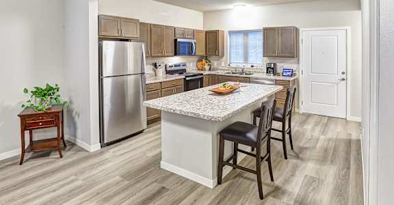 A kitchen with a table and chairs in the middle of the room.