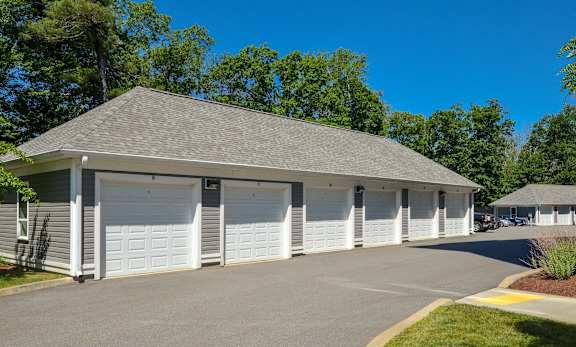 A building with a grey roof and white garage doors.