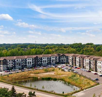 an aerial view of a building with a pond in front of it