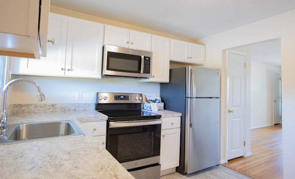 a kitchen with stainless steel appliances and white cabinets