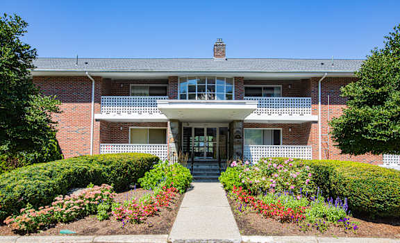 the front of a brick house with a sidewalk in front of it