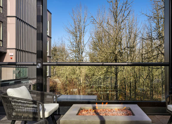 a living room with a large window and a fire pit