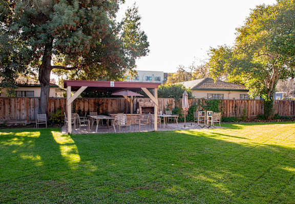 A backyard with a wooden fence and a gazebo.