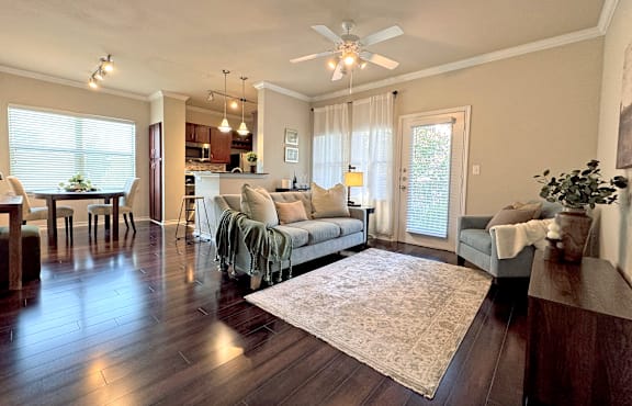 A living room with a grey couch, a coffee table, and a brick wall.