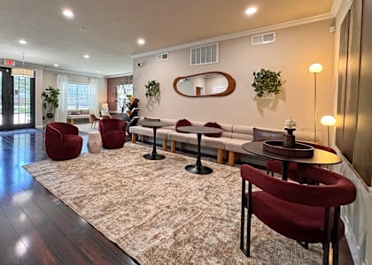 A room with a rug and chairs.