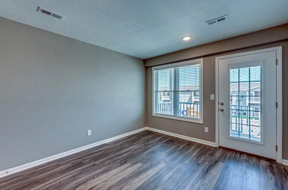 A room with a brown floor and a white door.