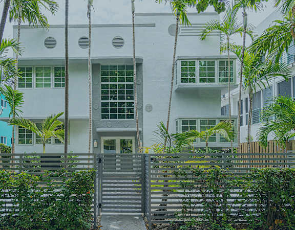 A Helios building with palm trees and foliage