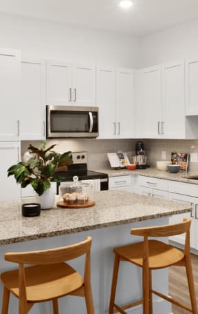 a kitchen with a large island with two stools in front of it