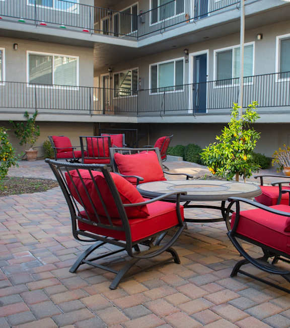 a patio with chairs and a table in a courtyard