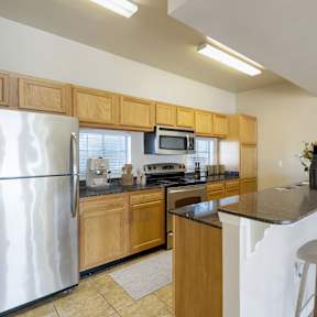 Kitchen with with a refrigerator, microwave, oven, and sink.