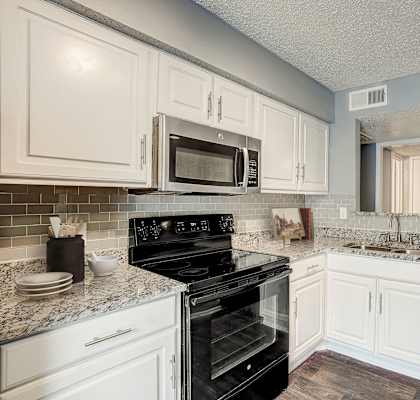 a kitchen with black appliances and white cabinets