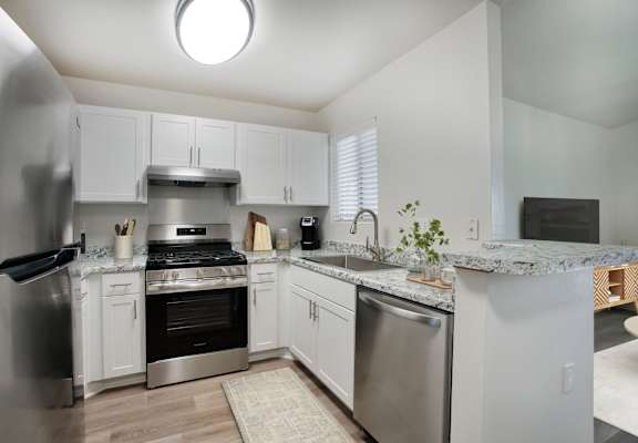 A kitchen with white cabinets and stainless steel appliances.