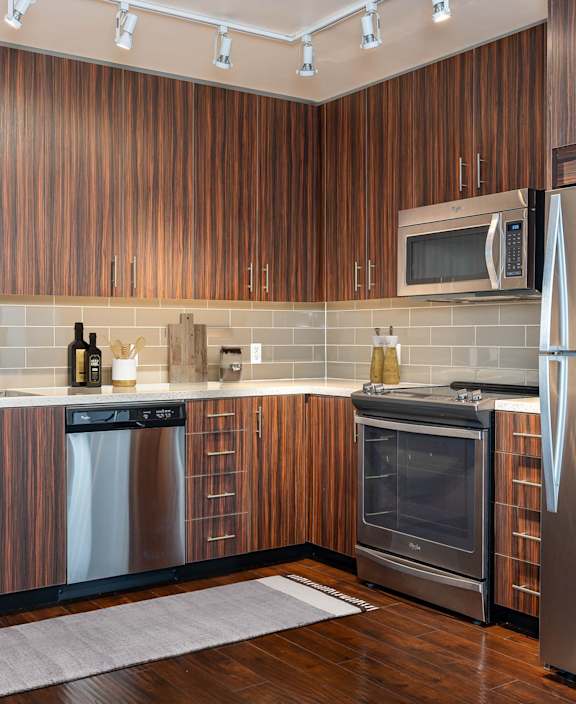 A modern kitchen with wooden cabinets and stainless steel appliances.