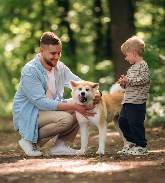 A man and a child are playing with a dog At The Dawson Cartersville in Cartersville, GA, 30121