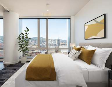 A bedroom with a large bed and a view of the city.