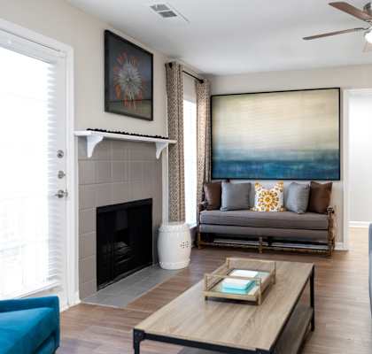 a living room with couches and a coffee table and a ceiling fan