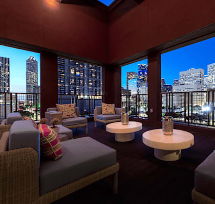 A room with a view of the city skyline at night.