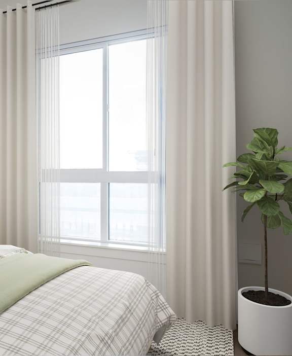 A bedroom with a bed, a lamp, a plant, and a painting on the wall.