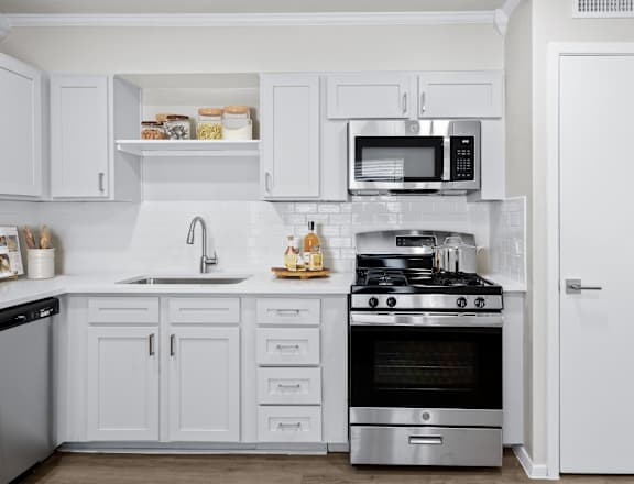 a kitchen with white cabinets and stainless steel appliances  at Sunset Heights, San Antonio, Texas