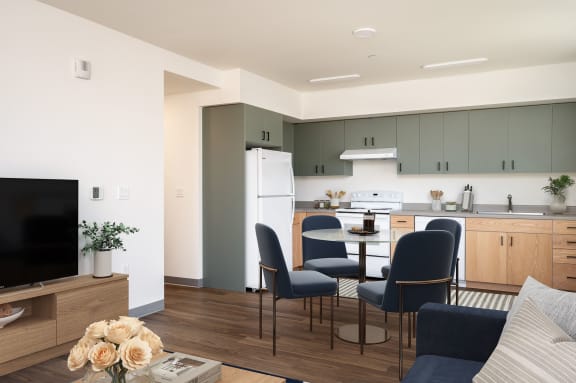 a living room and kitchen with a table and chairs