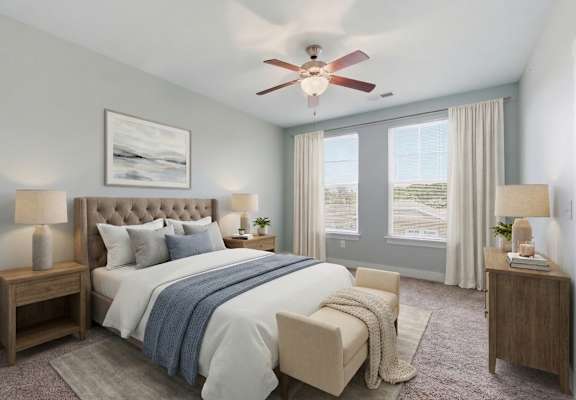 A bedroom with a large bed, a ceiling fan, and a painting on the wall.