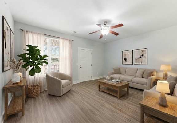 A living room with a ceiling fan and a large window with curtains.