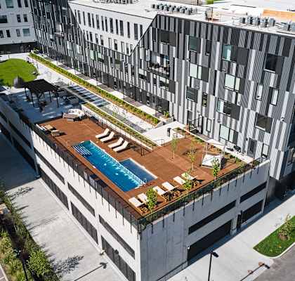 an aerial view of a building with a pool on top of it