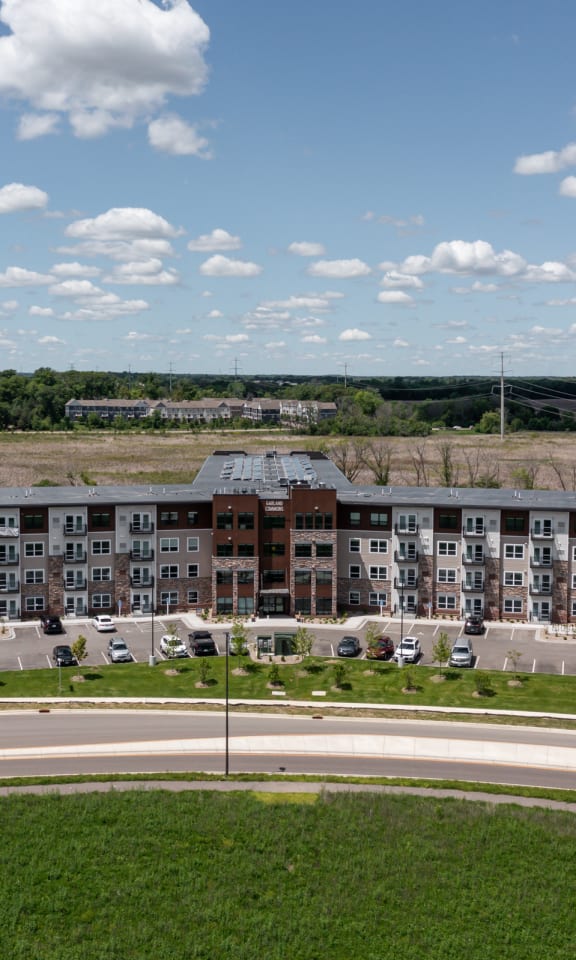 an aerial view of an apartment building overlooking a road and a field