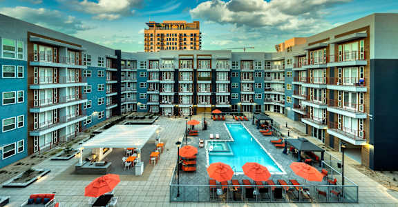 an overhead view of an apartment building with a swimming pool