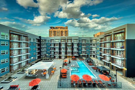 an overhead view of an apartment building with a swimming pool