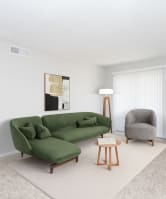 a living room with a green couch and a chair