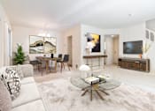 Thumbnail 14 of 22 - A modern living room with a glass coffee table and a white sofa.