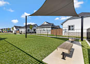 Thumbnail 5 of 6 - A park with a bench and a shade structure.