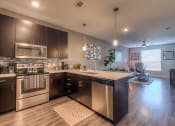 Thumbnail 25 of 78 - a kitchen with dark cabinets and stainless steel appliances  at EdgeWater at City Center, Lenexa, KS, 66219