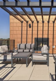 A patio with a table, chairs and a fireplace at Sonder Point 50+ Apartments, Brooklyn Center, MN, 55430