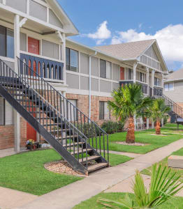 a row of apartments with stairs and palm trees at Castlewood Apartments, Texas, 77531