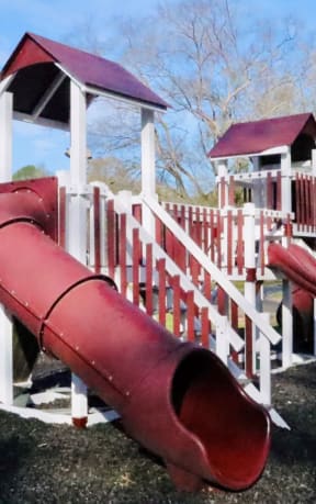 a playground with a red slide and a white playset at Uphill Flats, Georgia