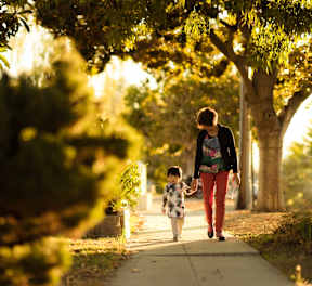 a mother and child walking down a sidewalk