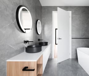 a bathroom with a white tub and a sink and a mirror