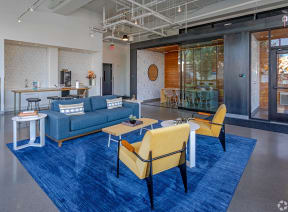a lobby with blue couches and chairs and a blue rug