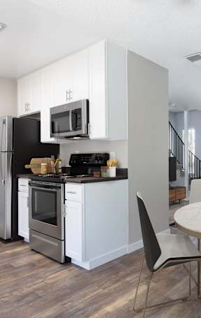 A modern kitchen with a dining table and chairs.