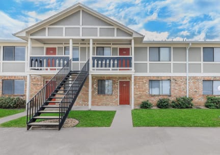 the outlook of a building with a staircase in front of it at Castlewood Apartments, Texas, 77531