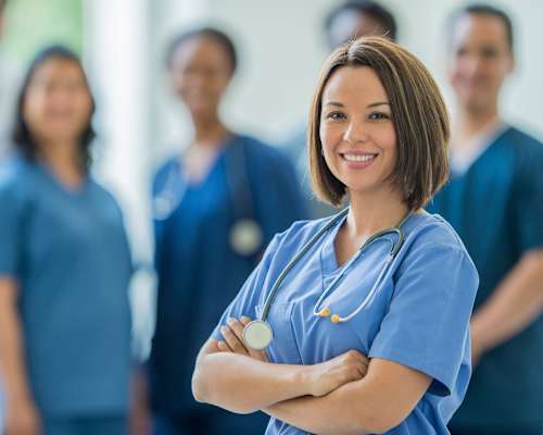 A group of medical professionals in blue scrubs stand in a line.