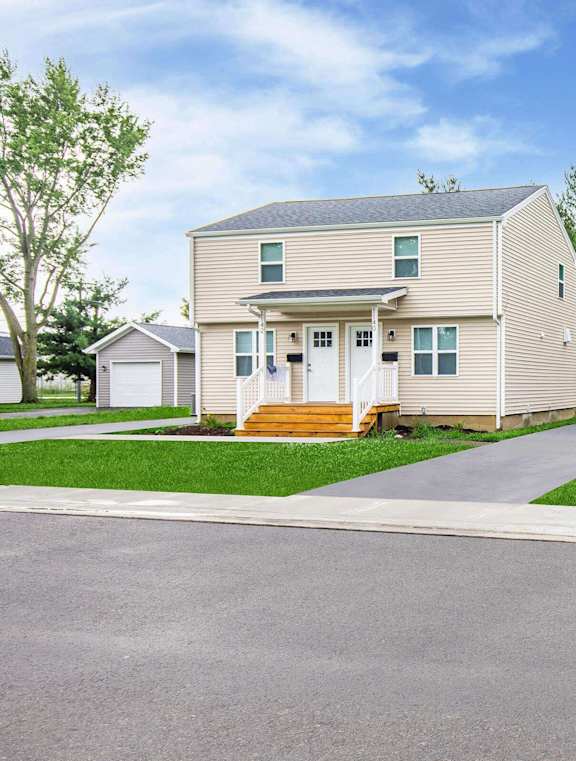 A house with a grey exterior and a white door is surrounded by a green lawn at Poplar Place Apartments, Springfield, Illinois