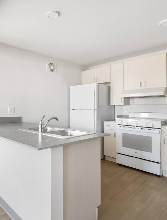 A kitchen with white appliances and a marble countertop at Poplar Place Apartments, Springfield, 62703
