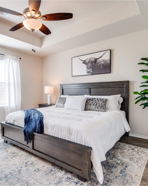 a bedroom with a large bed and a ceiling fan