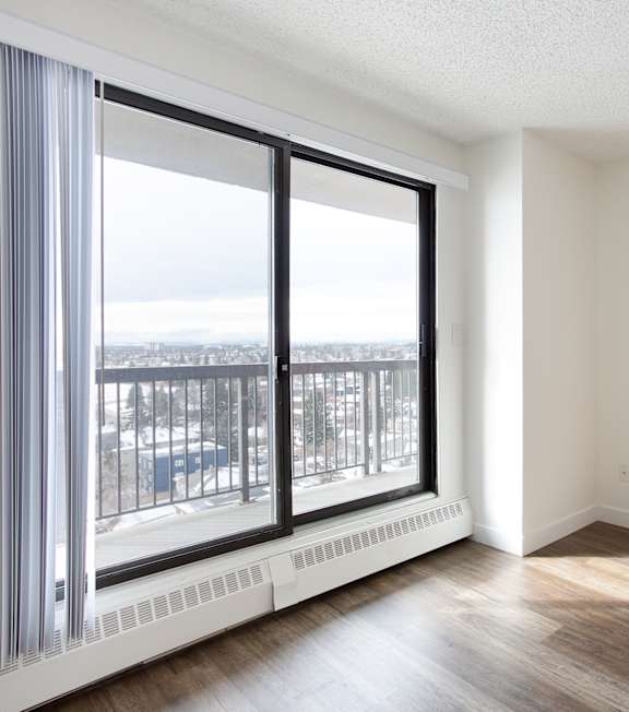 A room with a large window overlooking a balcony.