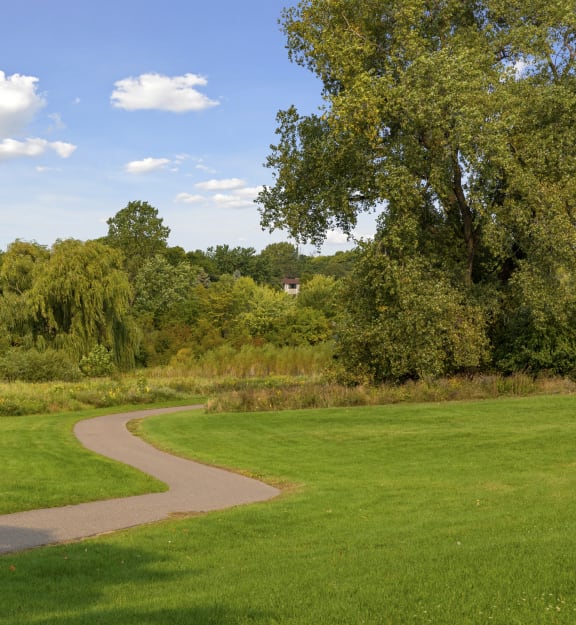 a path through a park with grass and trees at Villages on McKnight, St. Paul, Minnesota